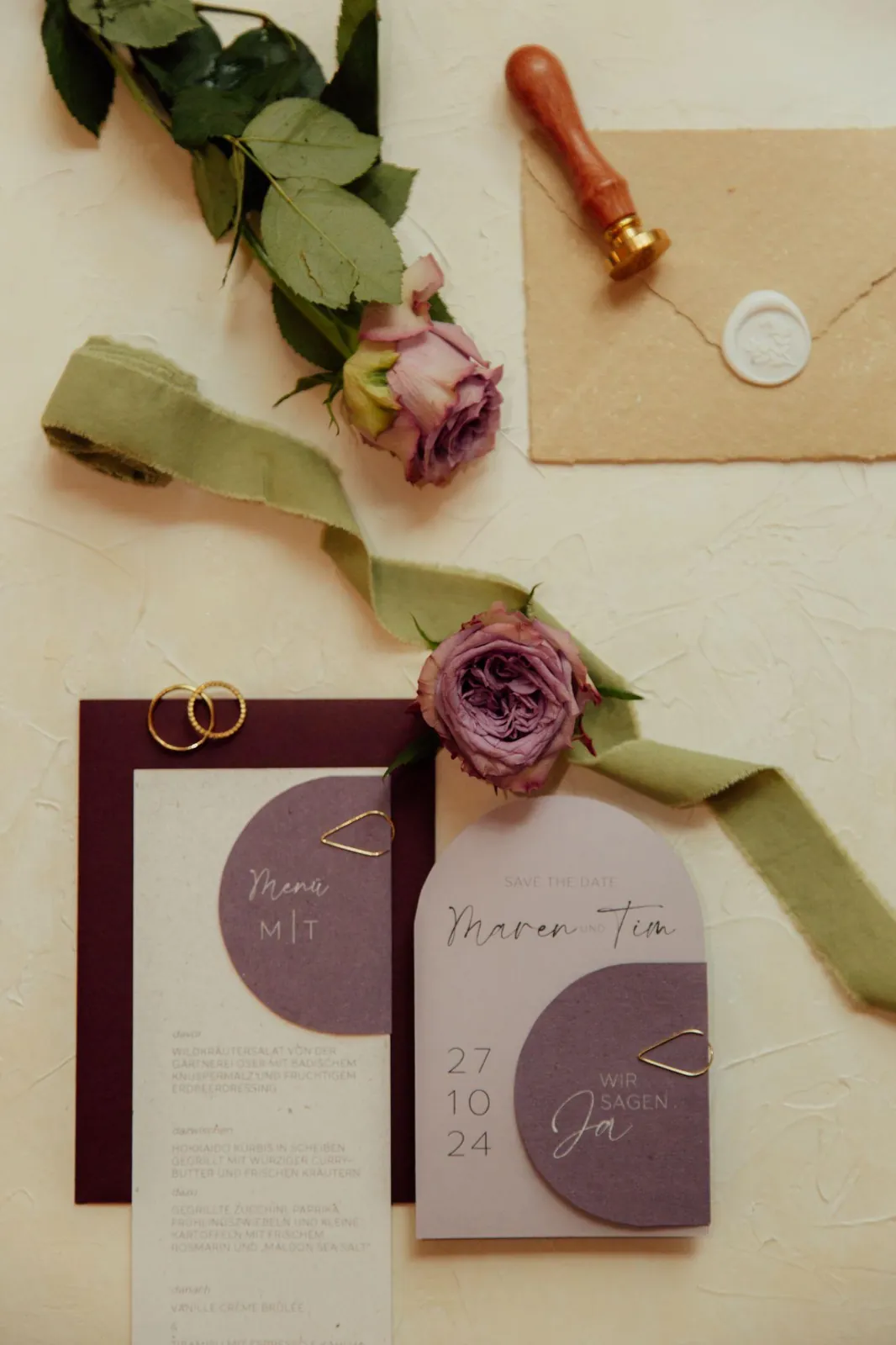 Save-the-Date-Karte, Eheringe und Wachssiegel als Flatlay